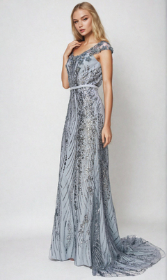 A woman stands against a plain light background wearing the floor-length Cinderella Couture 8057J Long Glitter Prom Dress, featuring off-the-shoulder styling with sequin and bead detailing.