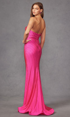 A woman poses against a gray backdrop wearing the Juliet JT2472R, a strapless long sequin prom dress in pink with a sweetheart neckline, fitted silhouette, slight train, and subtle vertical patterns.