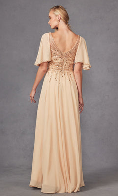A woman stands with her back to the camera against a gray background, wearing the Juliet JTM14F—a floor-length, blush chiffon A-line dress featuring short flutter sleeves and sequin embellishments on the bodice. This elegant style is a beautiful choice for a mother of the bride dress or any formal occasion.
