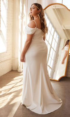 A woman in the Plus-Size Off-White Long Formal Gown KV1057WC stands indoors by a window and large mirror, sunlight streaming in.