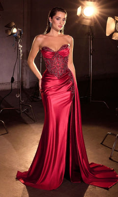 A woman poses in front of studio lights wearing the Beaded-Corset Strapless Prom Gown: Ladivine KV1131, a shiny, floor-length dress featuring a fitted beaded corset bodice.