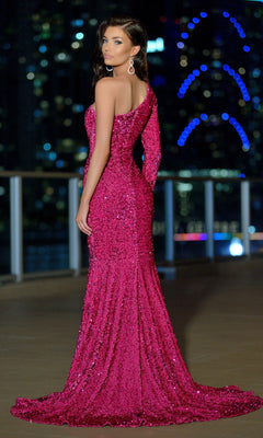 Woman in a Velvi One-Sleeve Long Black Sequin Prom Dress Rita stands outdoors at night, city lights and skyscrapers blurred behind her—an elegant, affordable designer look perfect for prom.