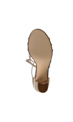 The Lupe Champagne Shimmer Prom Shoes (Touch Ups 4622) are beige high-heeled sandals with a smooth sole and open toe design, elegantly photographed against a white background.