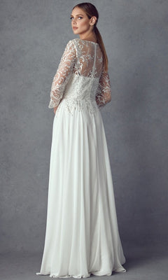 A woman wears the Long Formal Dress: Juliet M11, which features a chiffon skirt, sheer lace sleeves, an embroidered bodice, and a delicate lace back panel, while standing in front of a gray textured background.