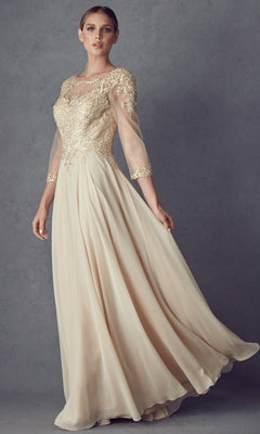 A woman wearing the Long Formal Dress: Juliet M12 in champagne, featuring sheer sleeves and intricate gold and floral lace embroidery with a chiffon A-line skirt, stands against a plain gray background.