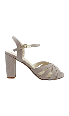 The Maeve Champagne Glitter Prom Shoes (Touch Ups 4529) are women’s heeled sandals with block heels, closed heel, ankle strap, open toe, and criss-cross fabric straps in a light beige. Perfect for prom!.