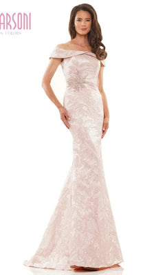 A woman stands against a white background wearing the Marsoni MV1223 long formal dress in rose, featuring an off-the-shoulder design, floor-length silhouette, floral pattern, and embellishments.