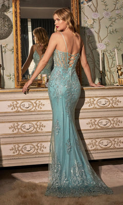 A woman wearing the Sheer-Corset Sleek Long Glitter Prom Dress OC007, a light blue mermaid gown with silver embellishments and a corset-style open back, stands before a mirror and ornate dresser.