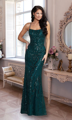 A woman wearing the PromGirl Statement-Back Long Sequin Prom Dress in dark green stands in an elegant room with ornate décor and a large window.