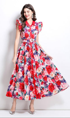 Model wearing  red and pink floral maxi dress standing in front of a white background.
