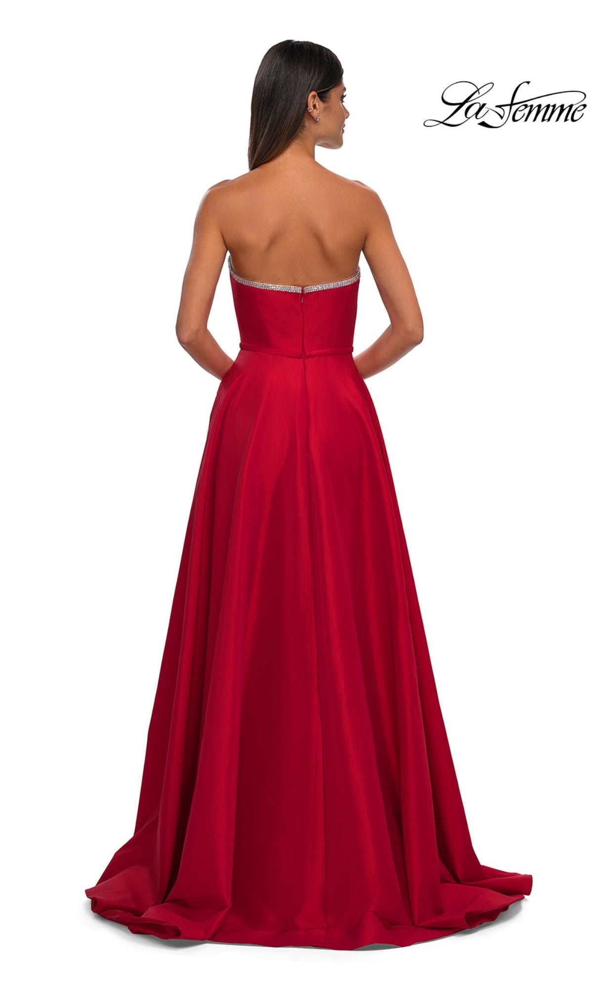 A woman is seen from the back wearing the La Femme 33063 Strapless Long A-Line Prom Dress in red, featuring a slight train and subtle rhinestone beading. The 