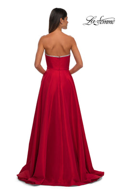 A woman is seen from the back wearing the La Femme 33063 Strapless Long A-Line Prom Dress in red, featuring a slight train and subtle rhinestone beading. The "La Femme" logo appears in the upper right corner.