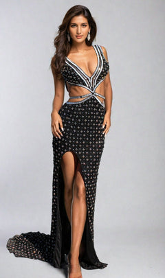 A woman poses against a plain background wearing the Aleta Cut-Out Sparkly Beaded Prom Dress 1191, a black evening gown featuring silver beading, cut-out sides, a high slit, and a deep V neckline.