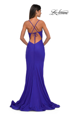 A woman in a floor-length, fitted royal blue dress with a crisscross open back and small train stands facing away, elegantly showcasing the Classic Long V-Neck Prom Dress: La Femme 33080.
