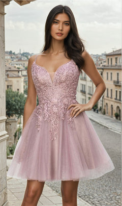 A woman poses outdoors on a stone street wearing the Corset-Back Short Glitter Homecoming Dress 5125J, a light pink, sleeveless A-line dress with a fitted bodice and glitter accents.