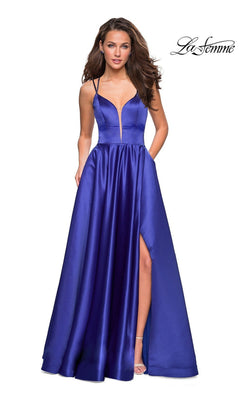 Woman wearing the La Femme Deep V-Neck Long A-Line Prom Dress 26994 in deep blue satin, featuring spaghetti straps, a plunging neckline, high slit, and open-back detail, stands against a plain white background.