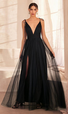 A woman in the Amoris SE005 Double-Slit Long V-Neck Prom Dress—an affordable sleeveless black A-line gown with shoulder ties, deep V neckline, high double slits, and sheer overlay—stands indoors in soft lighting.