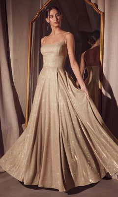 A woman stands in front of a mirror wearing the Classic Long Glitter Prom Dress: Amoris T213, holding out the full skirt to show off its shimmer and elegant, floor-length design with thin straps.