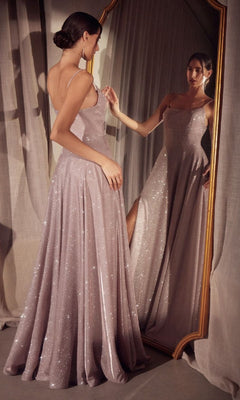 A woman stands in front of a mirror, admiring her reflection in the Classic Long Glitter Prom Dress: Amoris T213, a sparkly, floor-length lavender gown, with a sheer curtain behind her.