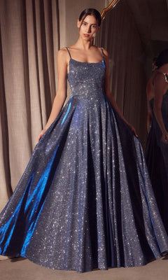 A woman stands indoors wearing the Classic Long Glitter Prom Dress: Amoris T213, a sparkling floor-length gown with thin straps and a full A-line formal skirt.