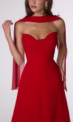 Woman wearing the Strapless Long Chiffon Prom Dress: Amoris T703 by Cinderella Divine, featuring a corset-style bodice and a sheer red scarf draped over her shoulders, posing against a plain background.