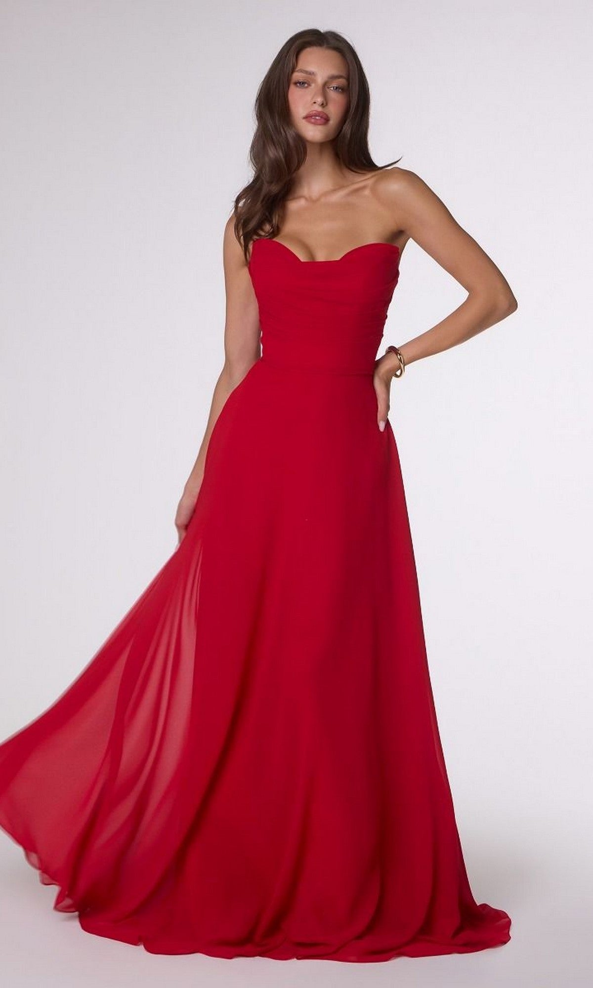 A woman wearing the Strapless Long Chiffon Prom Dress: Amoris T703, with a corset-style bodice and flowing skirt, stands against a plain light background.