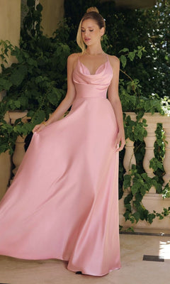 A woman in the Strappy Open-Back Long Prom Gown: Amoris T714 stands on a balcony, surrounded by lush green plants.