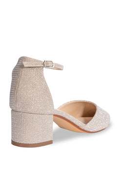 The Tegan Champagne Shimmer Prom Shoe by Touch Ups 4664 features a glittery finish, closed back, ankle strap with buckle, block heel, and pointed toe—shown here from the rear view.