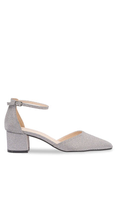The Tegan Silver Shimmer Prom Shoes (Touch Ups 4665) feature a pointed toe, low block heel, and buckle ankle strap in a silver-textured finish—shown in side profile as stylish closed-toe women’s shoes on a white background.