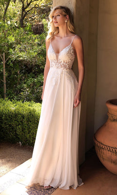 A woman stands outdoors in natural light wearing the Off-White Long Formal Dress with Sheer Bodice: Ladivine TY11, featuring thin straps and a deep V neckline. Greenery and an urn are visible in the background.