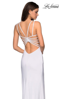 A woman in the La Femme Statement-Back Long Prom Dress 27072, a white sleeveless designer gown with multiple thin straps across the open back, stands looking to the side.