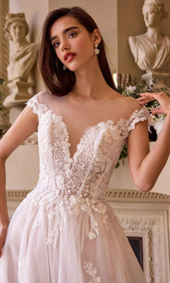 A woman in the Andrea and Leo WL038 long wedding dress stands indoors near classical statues and ornate decor.