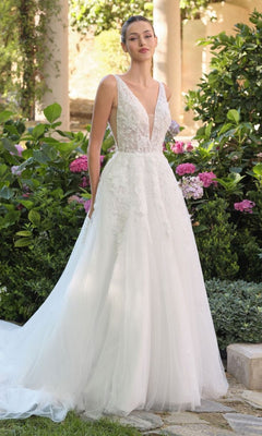 In a garden, a woman wears the Long Wedding Dress: Andrea and Leo WL064 in off white, featuring an A-line silhouette, deep V-neckline, floral lace bodice details, and a flowing tulle skirt.