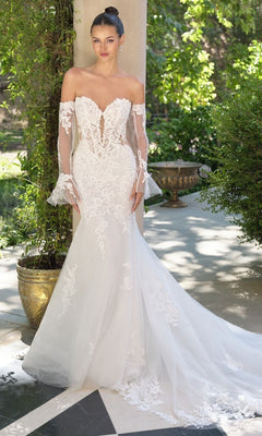 A woman stands outdoors in the Andrea and Leo WL065 long wedding dress, featuring a mermaid silhouette, sheer detachable lace sleeves, an off-the-shoulder lace bodice, and a flared tulle skirt.