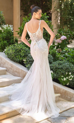 A woman stands on outdoor steps surrounded by greenery, wearing the Andrea and Leo WL066 long wedding dress featuring a fit-and-flare silhouette, beaded embroidery, and a sheer tulle skirt.