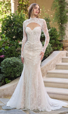 A woman stands outdoors before stairs and greenery, wearing the Andrea and Leo WL071 long wedding dress with a beaded lace strapless sweetheart neckline, styled with a detachable lace bolero for added elegance.