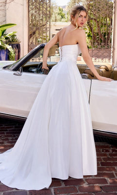 Wearing the Ladivine WN015 A-Line Long Classic White Dress with a sweetheart neckline and strapless design, a woman stands beside a white convertible car, looking over her shoulder.