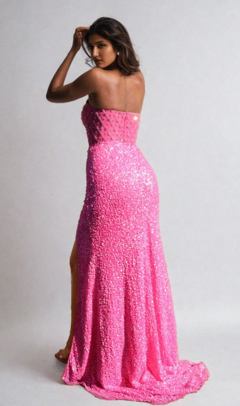 Woman wearing the Aleta Strapless Beaded Designer Prom Dress 1278, a sparkling floor-length pink gown with a high slit, posing with her back to the camera against a plain background.