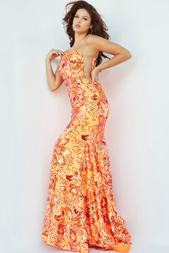 A woman poses in a one-shoulder Jovani prom dress adorned with floral sequins, standing against a plain white background.