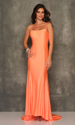 A woman stands before a gray textured backdrop in an Open-Back Long Formal Prom Dress by Dave & Johnny, featuring thin straps and a sleeveless, floor-length peach-orange design.