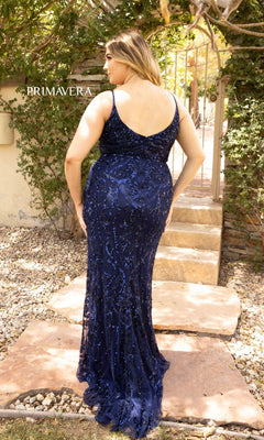 A woman wearing the Plus-Size Long Sequin Formal Dress 14001 in navy blue stands outdoors on stone steps, facing away. The dress features a fitted silhouette with allover sequins and a sleeveless, scoop-back design.