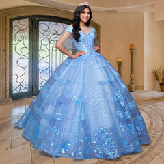 A young woman wearing the Quinceañera Sample Dress QF104 and a tiara stands indoors on a decorative tile floor in front of ornate double doors.
