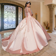 A woman wears the Quinceañera Sample Dress QF106, a pink sequin gown with embroidered details, as she stands indoors near ornate double doors and stone columns, glancing over her shoulder.