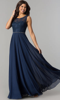 A woman poses against a plain background in the Lace-Bodice Long Chiffon Illusion-Neck Prom Dress, featuring a sleeveless navy blue design with a lace bodice and flowing floor-length skirt.