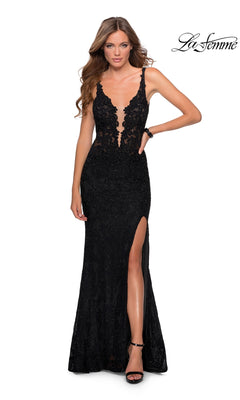 A woman stands against a white background in the La Femme Long Lace Prom Dress with Cut-Out Back, featuring lace detailing, a deep V-neckline, thigh-high slit, and black heels. This designer gown exudes elegance and sophistication.