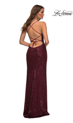 Woman in a La Femme Strappy Faux-Wrap Long Sequin Prom Dress in burgundy, featuring a crisscross open back, stands facing away from the camera.