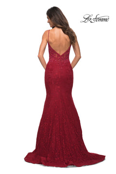 A woman models the La Femme Lace Sheer-Waist Long Mermaid Prom Dress in deep red with thin straps and a low V-back, posing against a white background. The "La Femme" logo is displayed in the top right corner.