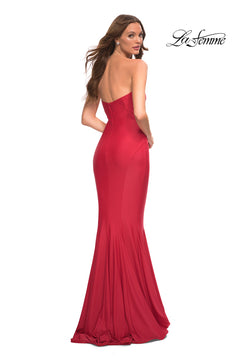 A woman stands looking over her shoulder in the La Femme Simple Mermaid Strapless Formal Dress, a fitted, floor-length red gown. The "La Femme" logo is displayed in the top right corner.