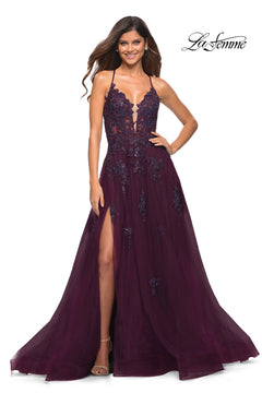 A woman smiles in a La Femme Open-Back Long Ball Gown with lace, deep purple and floor-length, featuring a plunging neckline and high leg slit. The La Femme logo appears in the corner.