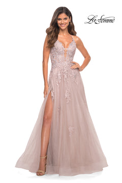 Woman in a mauve, sleeveless, floor-length La Femme Open-Back Long Ball Gown with floral lace, plunging neckline, high slit, and tulle skirt; "La Femme" logo appears in the upper right corner.